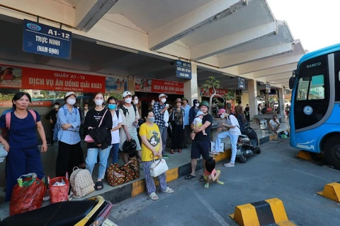 Hành khách đúng chờ xe về bến để có thể về quê trong dịp nghỉ Lễ Quốc khánh 2/9. (Ảnh: Việt Hùng/Vietnam+)