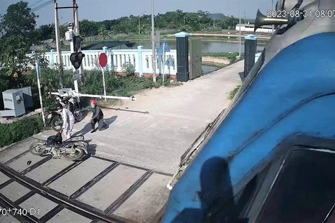 Nữ công nhân thông tin đường sắt Phạm Thị Hường cứu người thoát tai nạn tàu đâm trong gang tấc tại Nghệ An. (Ảnh trích xuất camera giám sát đường ngang).