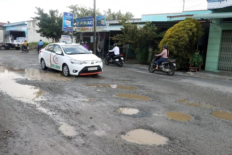 Một tuyến đường quốc lộ bị hư hỏng xuống cấp trầm trọng với những “ổ voi” sâu hoẵm, gây mất an toàn giao thông. (Ảnh: Lê Huy Hải/TTXVN)