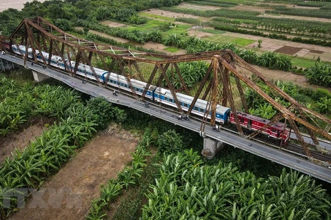 Tàu khách đi qua cầu Long Biên vào Ga Long Biên. (Ảnh: Thành Đạt/TTXVN)