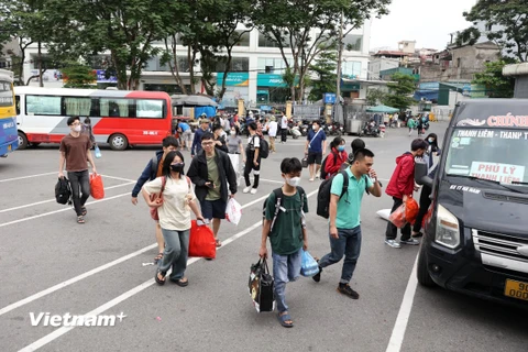 Người dân tay xách lỉnh kỉnh đồ đạc từ các tỉnh thành trở về Thủ đô trong ngày cuối của đợt nghỉ lễ 30/4-1/5. (Ảnh: Hoài Nam/Vietnam+)