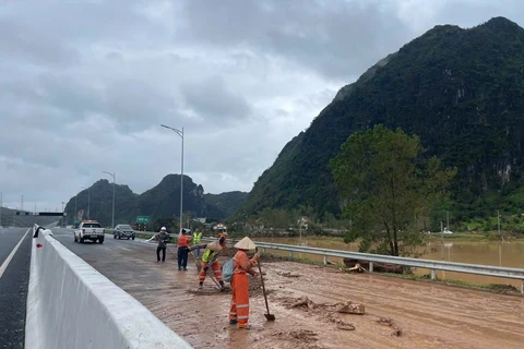 Nhân công nhân nỗ lực dọn dẹp, làm sạch đường trước khi thông bên trái hướng từ Đồng Lá đi Việt Hưng trên cao tốc Hạ Long-Móng Cái. (Ảnh: PV/Vietnam+)