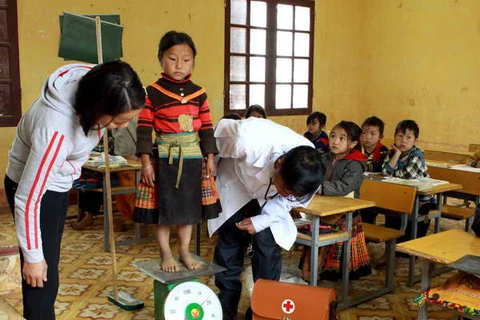 Kiểm tra sức khỏe học sinh trường tiểu học làng Chếu, Sơn La. (Ảnh: Dương Ngọc/TTXVN)