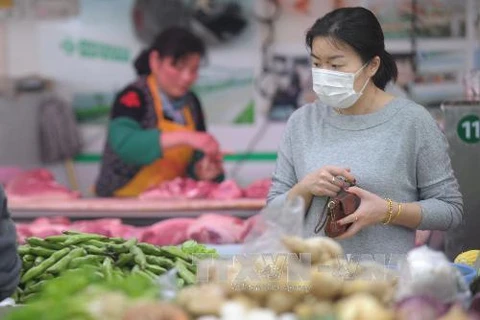 Người dân Trung Quốc đeo khẩu trang phòng chống lây nhiễm virus cúm gia cầm. (Nguồn: AFP/TTXVN)