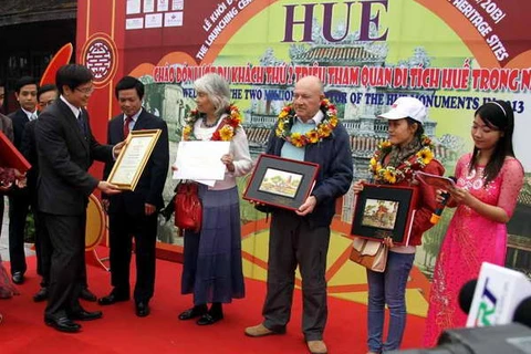 Ông Phan Thanh Hải, Giám đốc Trung tâm Bảo tồn di tích Cố đô Huế tặng quà cho các du khách thứ 1.999.999, 2.000.000 và 2.000.001 (Ảnh: Quốc Việt/Vietnam+)