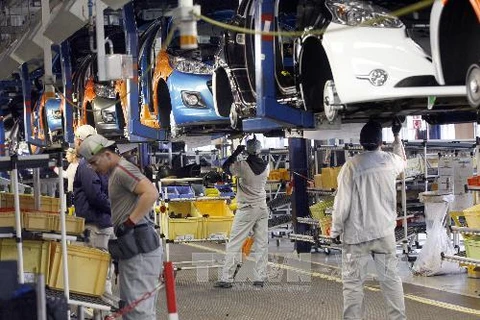 Công nhân làm việc trong nhà máy sản xuất xe Peugeot-Citroen tại Poissy, gần thủ đô Paris, Pháp. (Nguồn: AFP/TTXVN)
