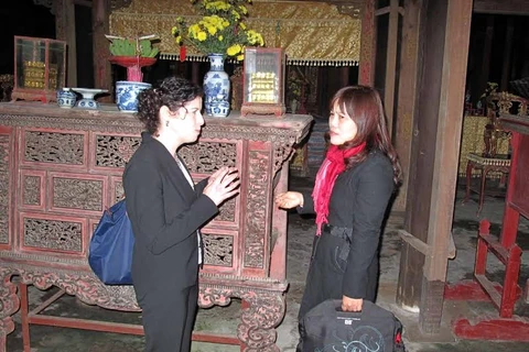 Tổng Lãnh sự Mỹ tại Việt Nam, bà Renna Bitter (trái) trao đổi việc phục hồi các án thờ tại Triệu Tổ Miếu. (Ảnh: Quốc Việt/Vietnam+)