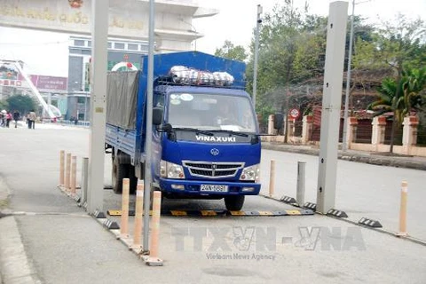 Phun dung dịch cloramin B 25% tự động cho xe tải hàng hóa nhằm ngăn ngừa virus cúm gia cầm tại cửa khẩu biên giới. (Ảnh: Nguyễn Thắng/TTXVN)