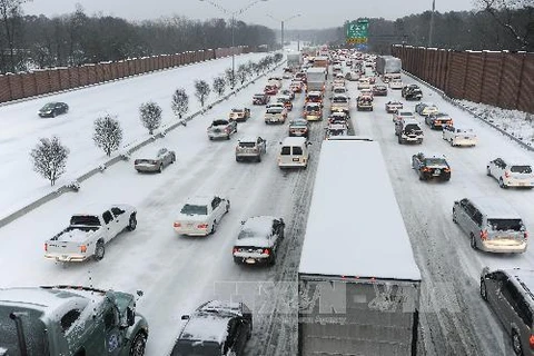 Các xe ôtô di chuyển chậm do tuyết rơi dày đặc tại Morrisville, Bắc Carolina ngày 12/2. (Nguồn: AFP/TTXVN)