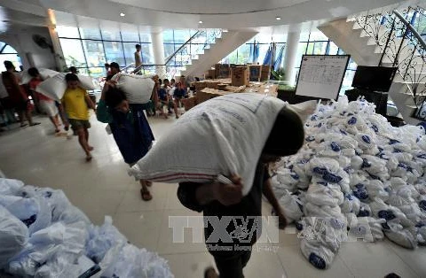Chuyển các bao gạo cứu trợ cho các nạn nhân ngập lụt ở thị trấn San Mateo, phía đông Manila. (Nguồn: AFP/TTXVN)