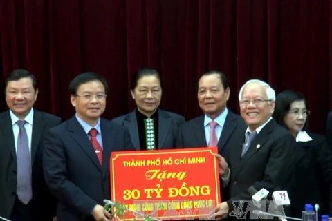 Ông Lê Thanh Hải trao tượng trưng số tiền 30 tỷ đồng của TP Hồ Chí Minh tặng nhân dân Điện Biên xây dựng Bệnh viện Đa khoa huyện Mường Ảng.( Ảnh: Chu Quốc Hùng/TTXVN)