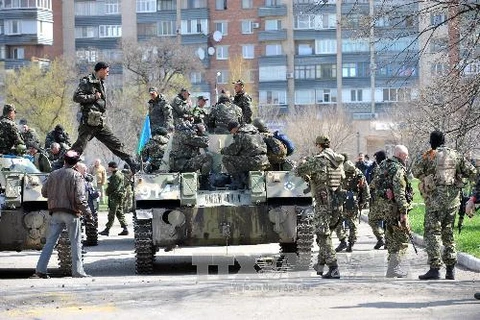 Xe bọc thép của một nhóm vũ trang chưa rõ thuộc lực lượng nào trấn giữ bên ngoài một tòa nhà chính quyền ở thành phố Slavyansk ngày 16/4. (Nguồn: AFP/TTXVN)