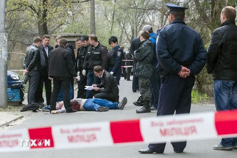 Cảnh sát điều tra tại hiện trường vụ sát hại nhà báo Oles Buzyna ở Kiev, Ukraine ngày 16/4. (Nguồn: AFP/TTXVN)