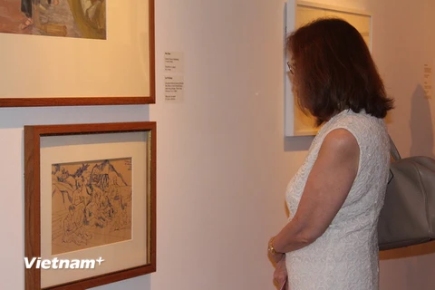 Người xem chăm chú trước các tác phẩm trưng bày tại triển lãm. (Ảnh: Lê Hải/Vietnam+)