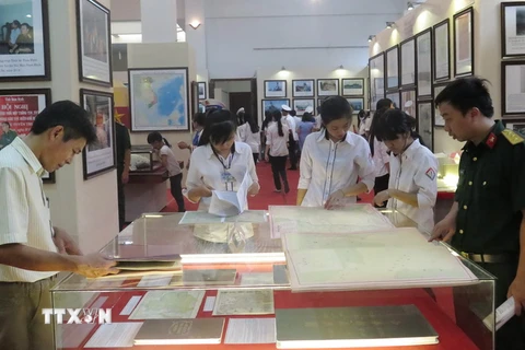 Người dân nghiên cứu các tài liệu, bản đồ - là chứng cứ lịch sử và cơ sở pháp lý về chủ quyền của Việt Nam đối với Hoàng Sa và Trường Sa tại Nam Định. (Ảnh: Văn Đạt/TTXVN)