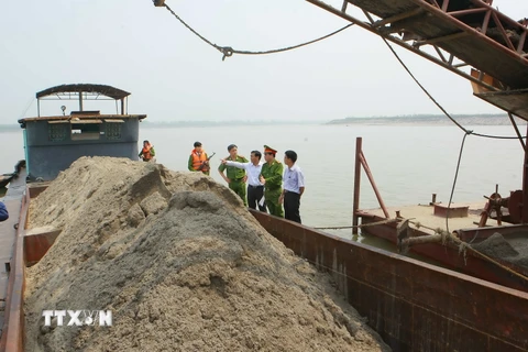 Đội Cảnh sát Môi trường Công an huyện Phúc Thọ xử lý doanh nghiệp khai thác cát trái phép. (Ảnh: Doãn Tuấn/TTXVN)