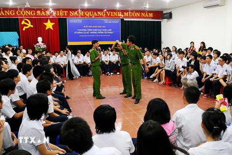 Các chiến sỹ công an giáo dục pháp luật, kỹ năng tự vệ - phòng chống tội phạm cho các em học sinh PTTH. (Ảnh: Mạnh Linh/TTXVN)