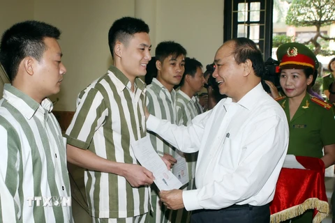 Phó Thủ tướng Nguyễn Xuân Phúc trao Quyết định đặc xá của Chủ tịch nước cho người được đặc xá. (Ảnh: Phạm Kiên/TTXVN)