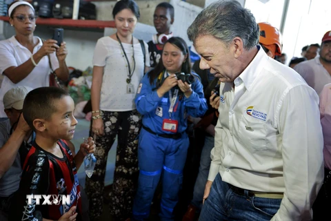 Tổng thống Colombia Juan Manuel Santos (phải) thăm những công dân Colombia bị trục xuất khỏi Venezuela tại Cucuta ngày 26/8. (Nguồn: THX/TTXVN)