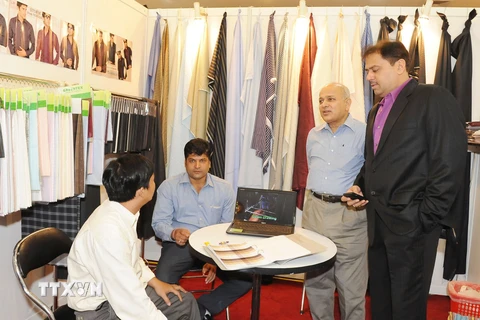 Các doanh nghiệp Việt Nam và doanh nghiệp Ấn Độ trao đổi về sản phẩm dệt may. (Ảnh: Kim Phương/TTXVN)