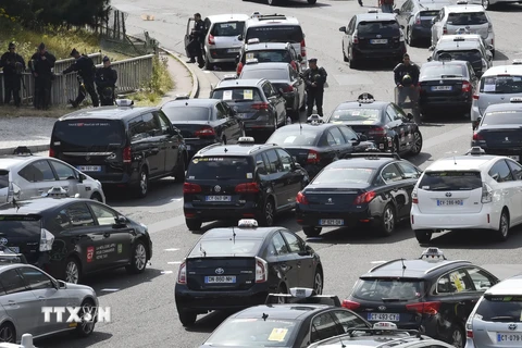 Các tài xế taxi chặn tuyến đường Porte Maillot trong cuộc biểu tình phản đối dịch vụ taxi giá rẻ UberPop ở Paris ngày 25/6. (Nguồn: AFP/TTXVN)