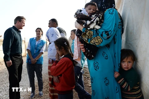 Thủ tướng Anh David Cameron (trái) thăm khu định cư cho người tị nạn ở thung lũng Bekaa, Liban ngày 14/9. (Nguồn: AFP/TTXVN)