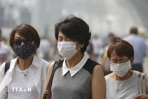 Người dân Singapore đeo khẩu trang để đối phó với tình trạng ô nhiễm khói bụi. (Nguồn: Reuters/TTXVN)
