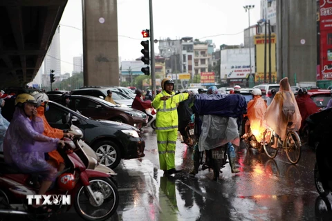 Cảnh sát giao thông vất vả điều tiết giao thông trên đường Nguyễn Trãi. (Ảnh: Phạm Kiên/TTXVN)