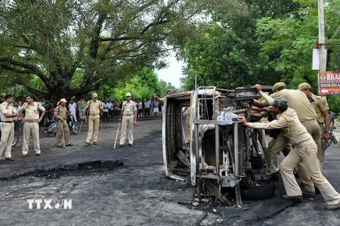 Cảnh sát Ấn Độ chuyển chiếc xe bị đốt cháy trong cuộc xung đột ở ngoại ô Jammu. (Nguồn: AFP/TTXVN)