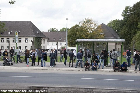 Những người di cư và người tị nạn chờ xe buýt bên ngoài trại Migrant ở ngoại ô thành phố Giessen. (Nguồn: Daily Mail)