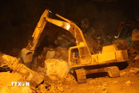 Phương tiện cơ giới xử lý hiện trường, tìm kiếm nạn nhân vụ sập mỏ đá đêm 22 rạng ngày 23/1. (Ảnh: Trịnh Duy Hưng/TTXVN)