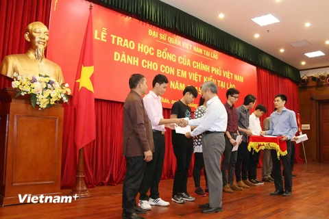 Đại sứ Nguyễn Mạnh Hùng trao quyết định nhận học bổng cho sinh viên Việt kiều chuẩn bị sang học tại Việt Nam. (Ảnh: Phạm Kiên/Vietnam+) 