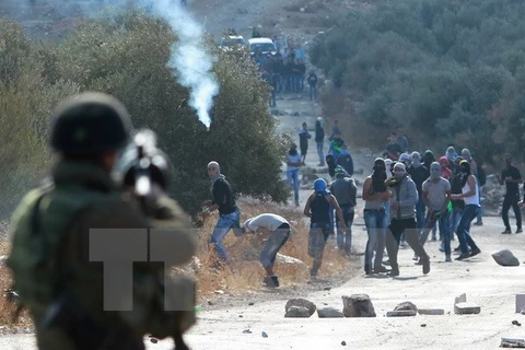Lực lượng an ninh Israel trấn áp người Palestine tại Khu Bờ Tây. (Nguồn: AFP/TTXVN)