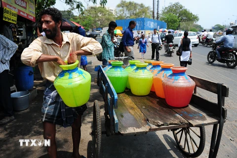 Người dân Ấn Độ xếp hàng lấy nước sạch tại một điểm phân phối nước miễn phí của Chính phủ ở Chennai ngày 22/3. (Nguồn: AFP/TTXVN)