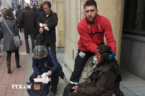 Nhân viên an ninh hỗ trợ người bị thương sau vụ nổ ở ga tàu điện ngầm Maalbeek ở Brussels ngày 22/3. (Nguồn: AFP/TTXVN)