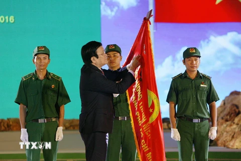 Chủ tịch nước Trương Tấn Sang trao Huân chương Độc lập hạng B lên lá cờ truyền thống của Lực lượng Thanh niên Xung phong TP.Hồ Chí Minh. (Ảnh: Thanh Vũ/TTXVN)