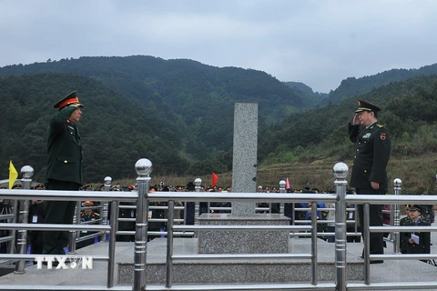 Hai Bộ trưởng Quốc phòng tiến hành nghi lễ chào Cột mốc 1223 tại Cửa khẩu Chi Ma. (Ảnh: Trọng Đức/TTXVN)