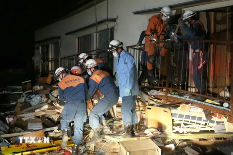 Lực lượng cứu hộ cứu một người dân khỏi căn nhà bị sập do động đất tại Kuammoto ngày 16/4. (Nguồn: AFP/TTXVN)