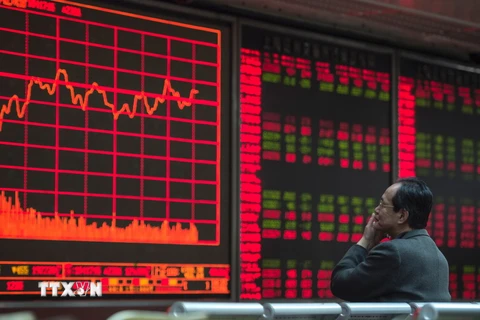 Nhà đầu tư theo dõi các chỉ số chứng khoán tại thủ đô Bắc Kinh. (Nguồn: AFP/TTXVN)