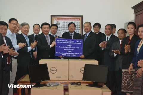 Giáo sư-tiến sỹ Nguyễn Xuân Thắng trao tặng máy tính cho Ban Tuyên huấn Trung ương Đảng NDCM Lào. (Ảnh: Xuân Chiến/Vietnam+) 