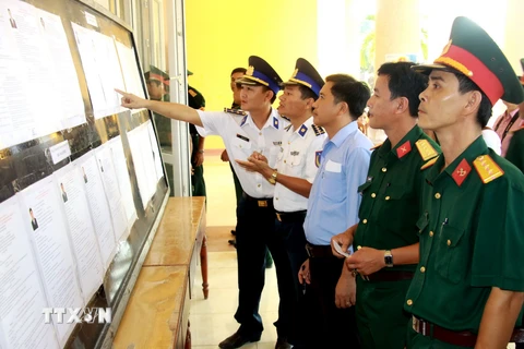 Cử tri thuộc các đơn vị lực lượng vũ trang huyện đảo Lý Sơn, Quảng Ngãi, tìm hiểu tiểu sử các ứng cử viên trước khi tiến hành bỏ phiếu. (Ảnh: Vĩnh Trọng/TTXVN)