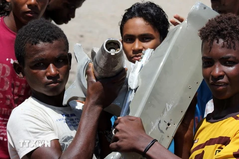 Trẻ em Yemen tìm thấy mảnh vỡ được cho là của máy bay chiến đấu của liên quân Arab gặp nạn ở Aden. (Nguồn: AFP/TTXVN)