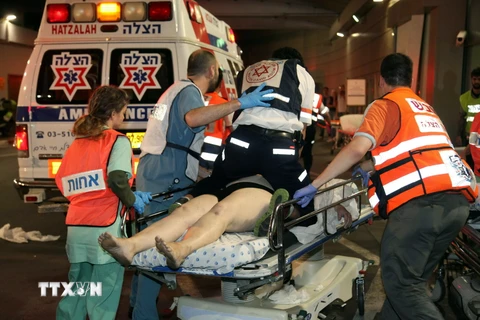 Nhân viên y tế Israel chuyển người bị thương tại hiện trường vụ tấn công tối 8/6. (Nguồn: AFP/TTXVN)