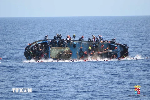 Người di cư nhảy khỏi con tàu bị lật ở ngoài khơi bờ biển Libya, gần Sicily (Italy) ngày 25/5. (Nguồn: EPA/TTXVN)