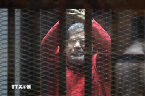 Cựu Tổng thống Mohammed Morsi đứng sau song sắt tại phiên tòa xét xử ông ở Cairo ngày 23/4. (Nguồn: THX/TTXVN)