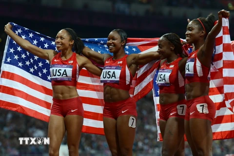 Các vận động viên Mỹ vui mừng sau khi lập kỷ lục thế giới mới tại cuộc thi chạy tiếp sức 4 x 100m nữ tại Thế vận hội Olympic 2012 diễn ra ở London (Anh). (Nguồn: AFP/TTXVN)