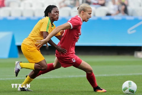 Cầu thủ Rebecca Quinn (phải) của Canada tranh bóng với cầu thủ Zimbabwe trong trận đấu. (Nguồn: AFP/TTXVN)