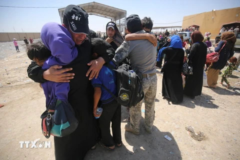 Một nhân viên an ninh Iraq vui mừng gặp lại người thân sau nhiều tháng xa cách. (Nguồn: AFP/TTXVN)
