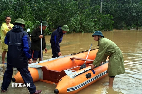 Lực lượng chức năng huyện Bà Chẽ huy động xuồng chở người dân đến nơi an toàn. (Ảnh: Nguyễn Hoàng/TTXVN)