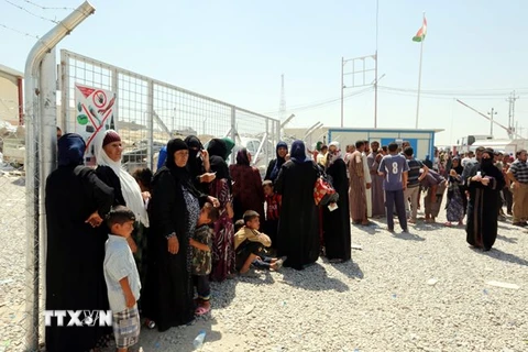 Người dân Iraq chờ nhận hàng cứu trợ tại trại tị nạn Dibaga, ngoại ô thành phố Mosul ngày 23/7. (Nguồn: EPA/TTXVN)